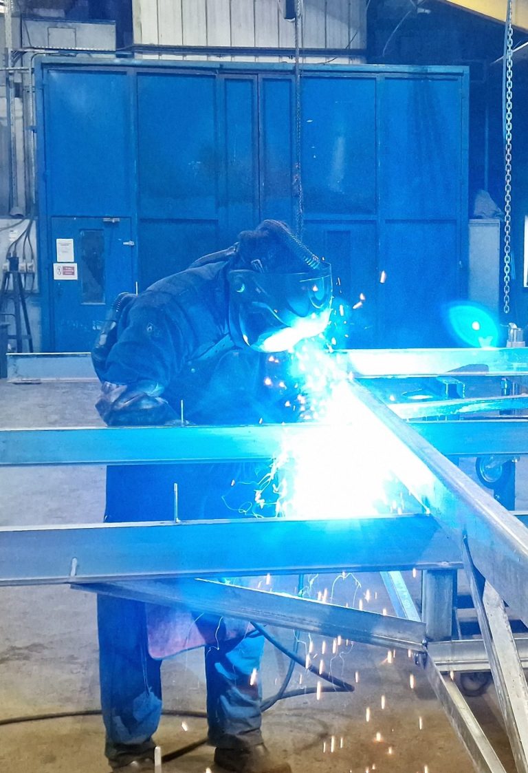 A welder sparks while working on metal with protective gear in Hull